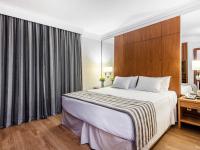 a hotel room with a large bed and a window at Hotel Cassino Tower Campinas Cambuí By Nacional Inn in Campinas
