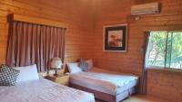 a bedroom with two beds in a log cabin at Yosemite Park B&amp;B in Ren&#39;ai