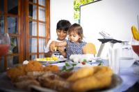 Un uomo e una bambina seduti a tavola mangiando cibo di Villa Sole a Kandy