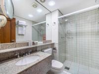 a bathroom with a sink and a toilet and a mirror at Hotel Cassino Tower Campinas Cambuí By Nacional Inn in Campinas