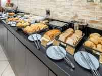 a buffet line with bread and pastries and other foods at Hotel Cassino Tower Campinas Cambuí By Nacional Inn in Campinas