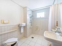 a bathroom with a shower and a sink and a toilet at Hotel Cassino Tower Campinas Cambuí By Nacional Inn in Campinas