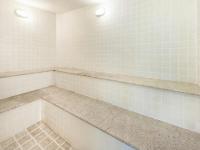 a bathroom with white tiled walls and two lights at Hotel Cassino Tower Campinas Cambuí By Nacional Inn in Campinas