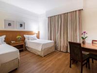 a hotel room with two beds and a desk at Hotel Cassino Tower Campinas Cambuí By Nacional Inn in Campinas