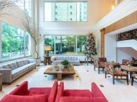 a living room with red furniture and a christmas tree at Hotel Cassino Tower Campinas Cambuí By Nacional Inn in Campinas