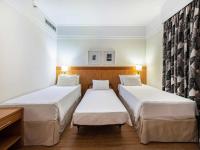 a hotel room with two beds and a desk at Hotel Cassino Tower Campinas Cambuí By Nacional Inn in Campinas