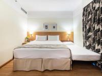 a bedroom with a large bed with white sheets at Hotel Cassino Tower Campinas Cambuí By Nacional Inn in Campinas