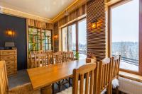 a dining room with a wooden table and chairs at Rich OAK - готель з відкритим панорамний басейном in Yablunytsya
