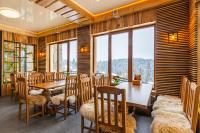 a dining room with a table and chairs and windows at Rich OAK - готель з відкритим панорамний басейном in Yablunytsya