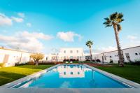 a swimming pool in front of a house with a palm tree at Baglio Custera in Marsala