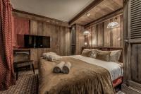 a bedroom with a bed with two pairs of shoes on it at HOTEL LE VAL D&#39;ISERE in Val-d&#39;Isère