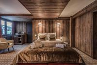 a bedroom with a large bed with wooden walls at HOTEL LE VAL D&#39;ISERE in Val-d&#39;Isère