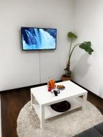 a living room with a white table and a tv on a wall at Modern Apartment 2 in Brčko