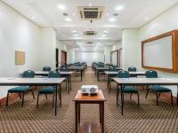 a classroom with tables and chairs and a projector at Hotel Cassino Tower Campinas Cambuí By Nacional Inn in Campinas