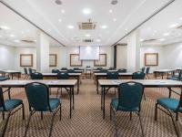 a conference room with tables and chairs and a projection screen at Hotel Cassino Tower Campinas Cambuí By Nacional Inn in Campinas