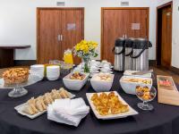 a black table with plates of food on it at Hotel Cassino Tower Campinas Cambuí By Nacional Inn in Campinas