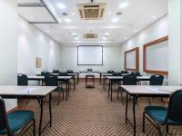 a classroom with tables and chairs and a white wall at Hotel Cassino Tower Campinas Cambuí By Nacional Inn in Campinas