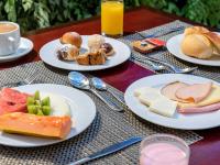 a table with plates of food on a table at Hotel Cassino Tower Campinas Cambuí By Nacional Inn in Campinas