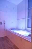 a bathroom with a bath tub and a window at La Demeure des Sacres - Cathédrale in Reims