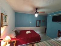 a bedroom with a red bed and blue walls at Hospedagem Recanto dos Ties in Abraão