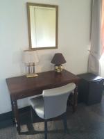 a desk with a chair and a lamp and a mirror at Hôtel Saint Alban in Saint-Maur-des-Fossés