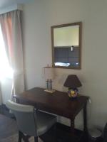 a desk in a room with a mirror and a lamp at Hôtel Saint Alban in Saint-Maur-des-Fossés