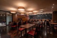 東京にあるホテルマイステイズ 御茶ノ水 コンファレンスセンターのテーブルと椅子とバーのあるレストラン