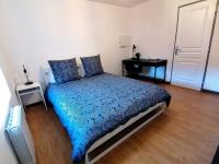 a bedroom with a bed with a blue comforter at Grand Appartement 2 chambres avec Fibre et Netflix in Belfort