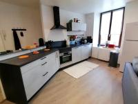 a kitchen with white cabinets and a black counter top at Grand Appartement 2 chambres avec Fibre et Netflix in Belfort