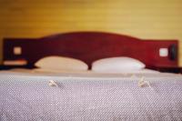a bed with a wooden headboard and white pillows at Grand Hotel De La Poste - Lyon Sud - Vienne in Vienne