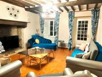 a living room with blue furniture and a fireplace at Gîte Eloquent in Gratot