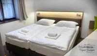 a bed with two white towels on top of it at Végvári Vendégház in Magyarbóly