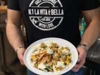 un homme tient un bol de nourriture dans l'établissement Paso a Paso, à Terlizzi