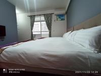 a large white bed in a bedroom with a window at 伊家民宿Yi home 志航路一段398號 in Taitung City