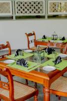 una mesa de madera con servilletas verdes y platos en ella en Villa Birdlake, en Hikkaduwa