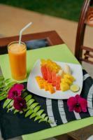 un plato de fruta en una mesa con una bebida en Villa Birdlake, en Hikkaduwa