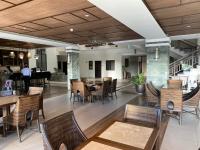 a restaurant with tables and chairs and a person in the background at Rosarich Homestay - Bristle Ridge Residences in Baguio