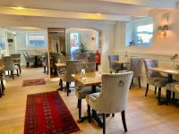 um restaurante com mesas e cadeiras e um tapete vermelho em Hotel Concordia em Lund