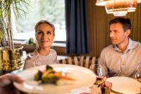 セルヴァ・ディ・ヴァル・ガルデーナにあるVilla Genzianaの2人がテーブルに座り、食べ物の皿を囲んでいる