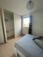 ein Schlafzimmer mit einem Bett und einem begehbaren Kleiderschrank in der Unterkunft Appartement moderne en résidence avec piscine in Mèze