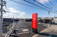 un estacionamiento vacío con un letrero rojo. en HOTEL R9 The Yard Nakatsu, en Nakatsu