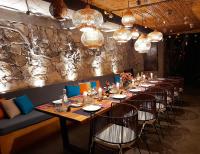 una mesa larga en un restaurante con sillas y luces en Atitlan Sunset Lodge, en Santa Cruz La Laguna