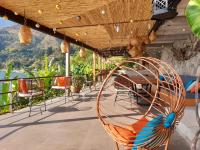 una silla en el balcón con vistas al agua en Atitlan Sunset Lodge, en Santa Cruz La Laguna