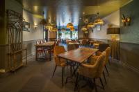 Un comedor con mesas y sillas de madera. en Hôtel du Musée, en Granville