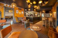 Un restaurante con mesas y sillas y un bar. en Hôtel du Musée, en Granville