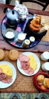 a table with plates of breakfast foods and a teapot at La Dragonne, petite maison au centre de Bellême, jardin, cuisine équipée, vue forêt in Bellême