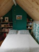 a bedroom with a white bed with a green wall at La Bonne Etoile, près Giverny in Vernon