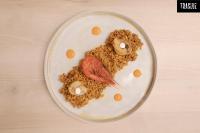 Un plato de comida con carne y huevos encima. en Melia Alicante, en Alicante