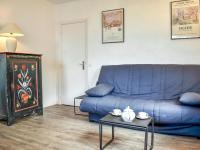 ein blaues Sofa im Wohnzimmer mit einem Tisch in der Unterkunft Apartment Castel Guermante by Interhome in Deauville