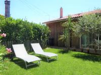 two white chairs sitting in the grass in a yard at Holiday Home Le Chant Des 4 Sirènes by Interhome in La Teste-de-Buch